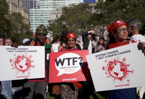 Protesters demanding climate justice holding banners which read 'system change, not climate change'