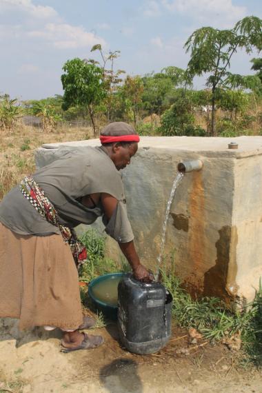 Esther draws water from a bole hole drilled by Konkola Copper Mines (KMC), a Vedanta subsidiary. She explains the water is still dangerous because the pollution has contaminated the water table. 
